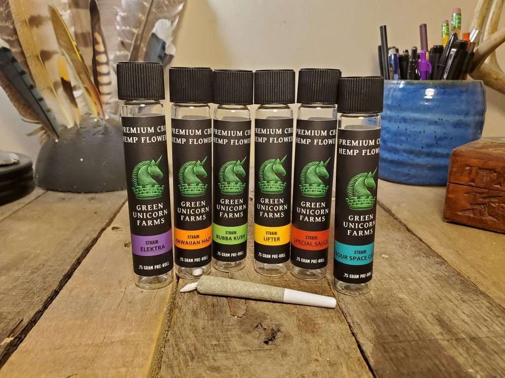 Six glass containers of Green Unicorn Farms CBD pre-rolls