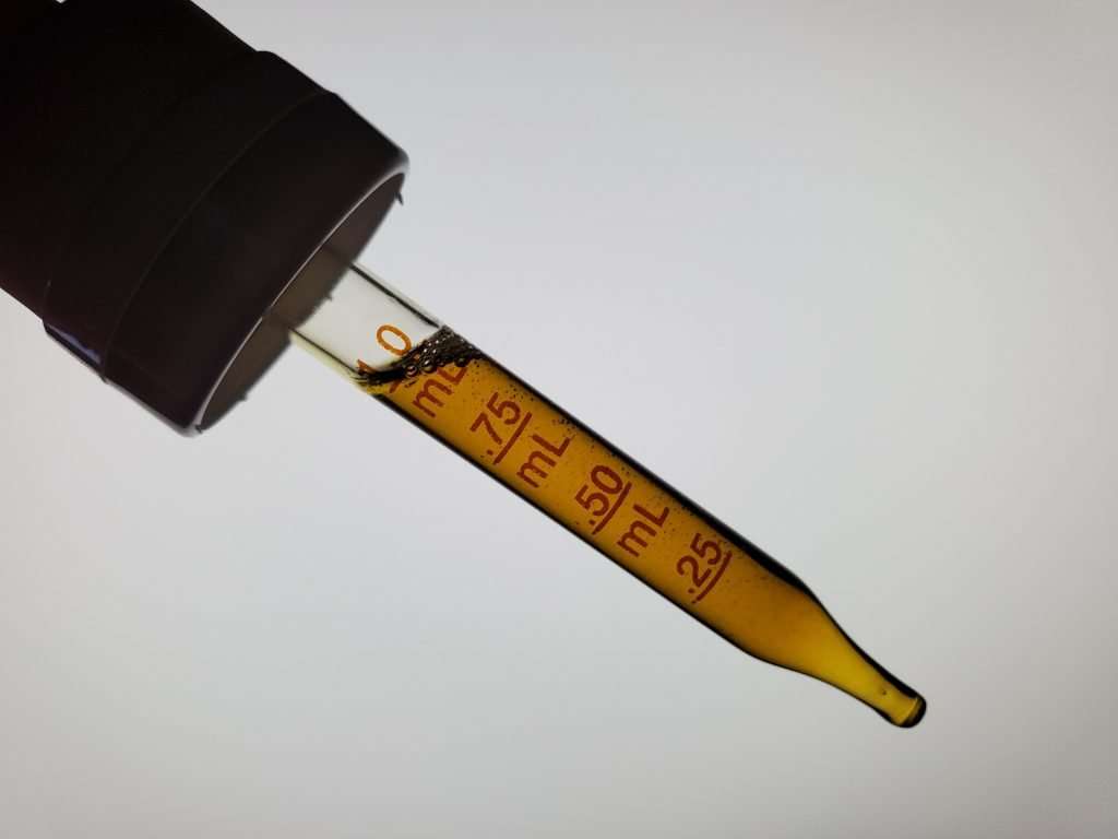 4 Corners Cannabis CBD oil in a tincture dropper with an amber appearance on a white background
